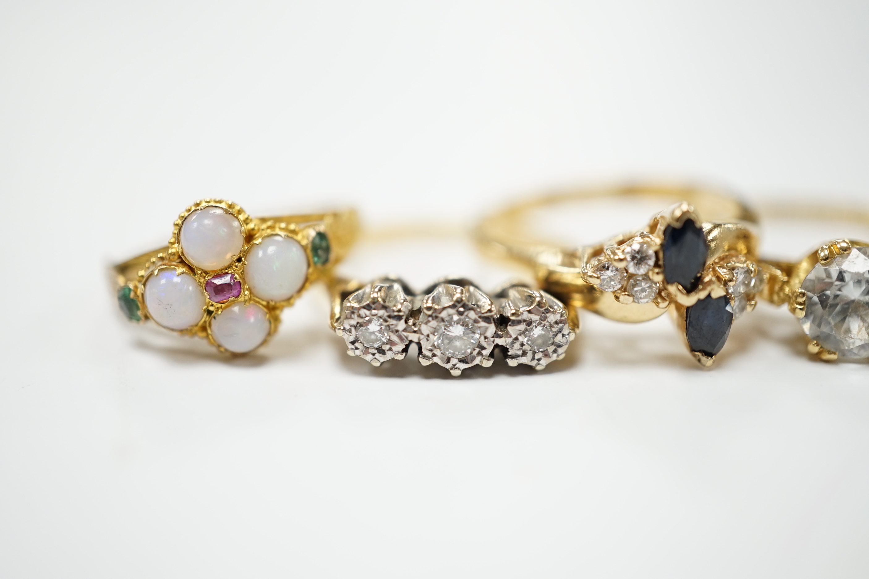 An Edwardian 15ct?, white opal, emerald and amethyst cluster set ring, in the Suffragette colours, size F, together with four other yellow metal and gem set rings including three stone illusion set diamond and a 14k sapp